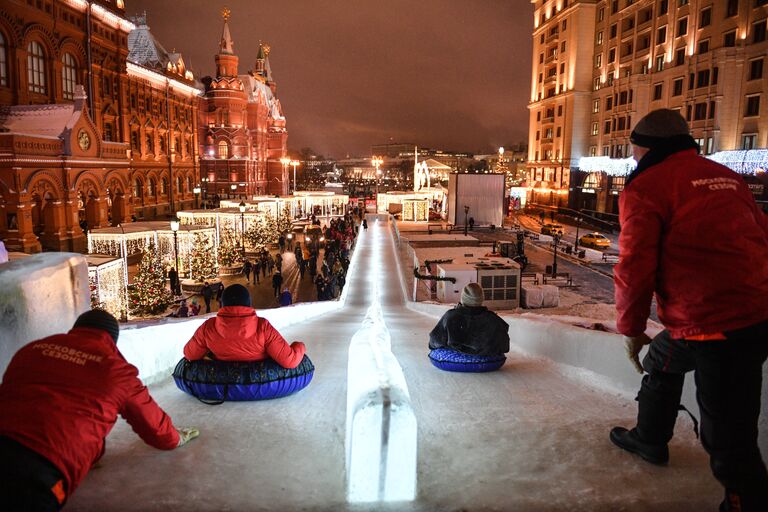 Москвичи на ледяной горке на Манежной площади, где открылся фестиваль Путешествие в Рождество