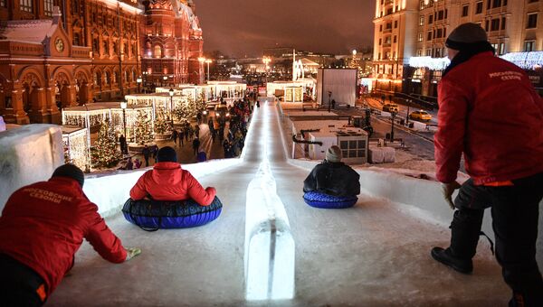 Москвичи на ледяной горке на Манежной площади, где открылся фестиваль Путешествие в Рождество