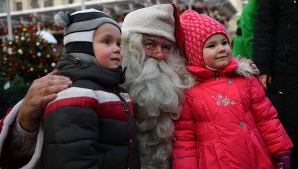 Санта-Клаус фотографируется с детьми на открытии Дома Санты в рамках фестиваля Путешествие в Рождество на Тверской площади в Москве
