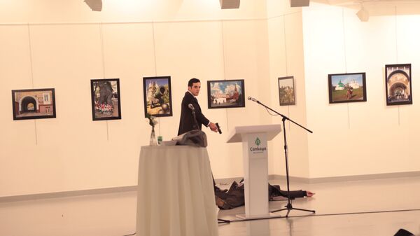 Вооруженный мужчина рядом с телом посла РФ в Турции Андрея Карлова в галерее в Анкаре. Архивное фото