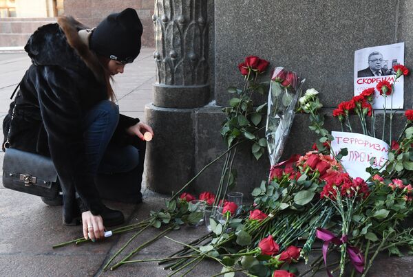 Девушка зажигает свечу у здания министерства иностранных дел РФ в связи с гибелью посла России в Турции Андрея Карлова.. 20 декабря 2016