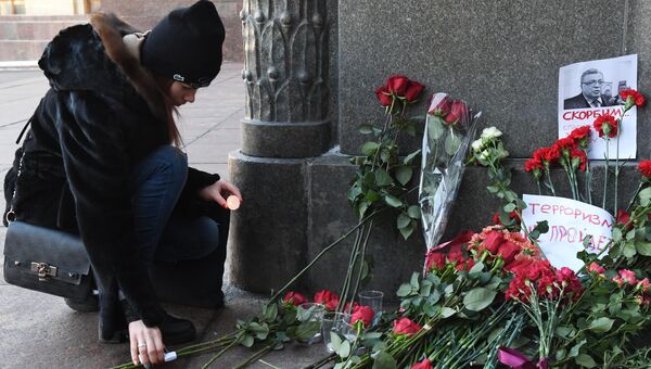 Девушка зажигает свечу у здания министерства иностранных дел РФ в связи с гибелью посла России в Турции Андрея Карлова.. 20 декабря 2016