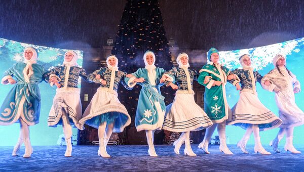 Девушки в костюмах снегурочек танцуют во время тожественного зажжения иллюминации на главной ёлке в Самаре