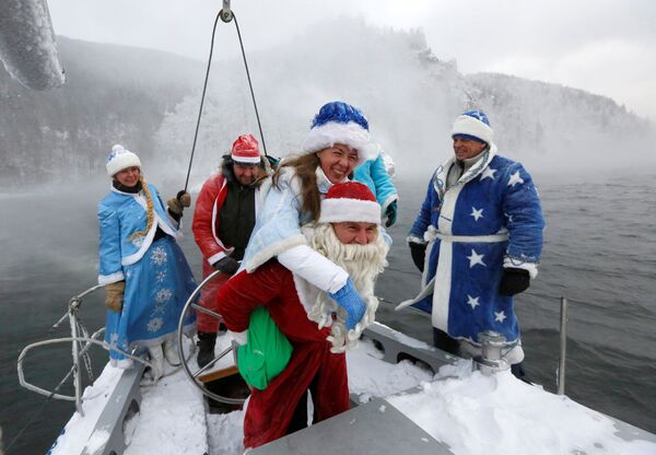 Участники яхт-клуба в костюмах Деда Мороза и Снегурочки на реке Енисей в Красноярске