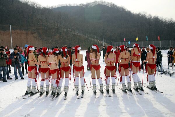 Девушки в костюмах Санта Клауса на горнолыжном курорте в провинции Хэнань в Китае