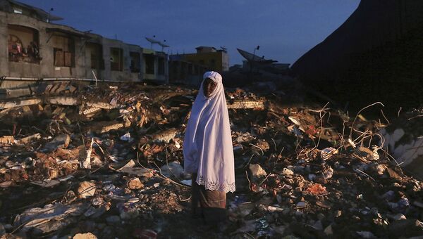 Женщина среди руин рынка после землетрясения в Индонезии. 8 декабря 2016