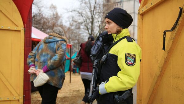 Сотрудница полиции охраняет вход на рождественскую ярмарку в Магдебург, Германия