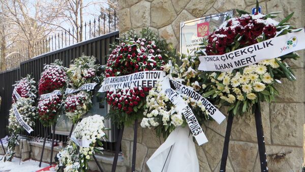 Цветы в памяти о погибшем после РФ в Турции Андрее Карлове у входа в посольство РФ в Анкаре