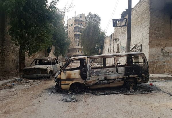 Сгоревшие автомобили в освобожденном квартале восточного Алеппо в Сирии