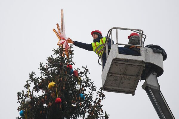 Рабочие украшают Новогоднюю ёлку на Соборной площади Кремля в Москве