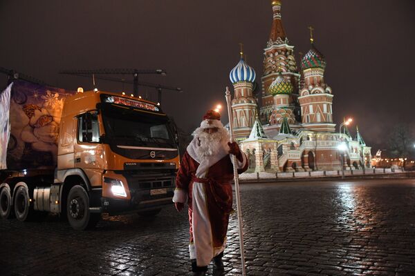 Дед Мороз возле специального автопоезда с главной Новогодней елкой России перед въездом на территорию московского Кремля