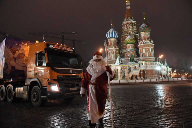 Дед Мороз возле специального автопоезда с главной Новогодней елкой России перед въездом на территорию московского Кремля