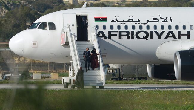 Пассажиры покидают самолет ливийской авиакомпании Afriqiyah Airways в аэропорту Мальты. 23 декабря 2016