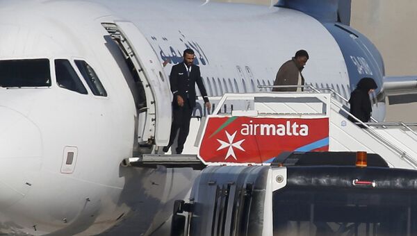 Пассажиры покидают самолет ливийской авиакомпании Afriqiyah Airways в аэропорту Мальты. 23 декабря 2016