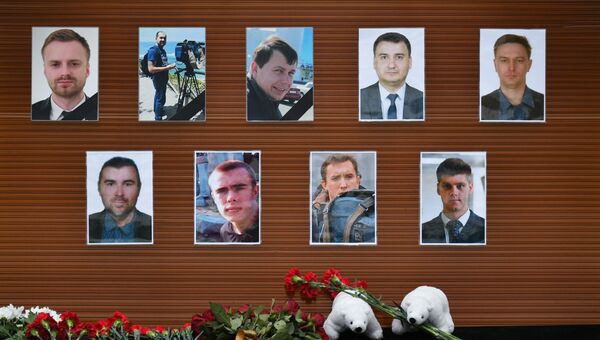 Цветы, возложенные у телевизионного центра Останкино к фотографиям журналистов, погибших при крушении самолета Минобороны РФ Ту-154