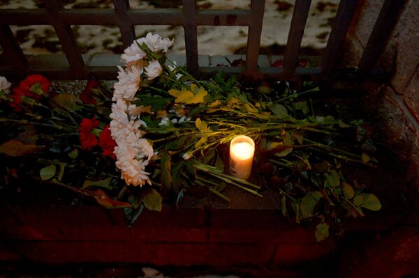 К зданию посольства Российской Федерации в Минске люди несут цветы и свечи