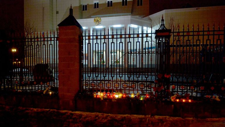 К зданию посольства Российской Федерации в Минске люди несут цветы и свечи
