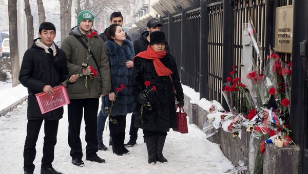 Жители Бишкека приносят цветы к посольству России в память о погибших при крушении самолета Ту-154