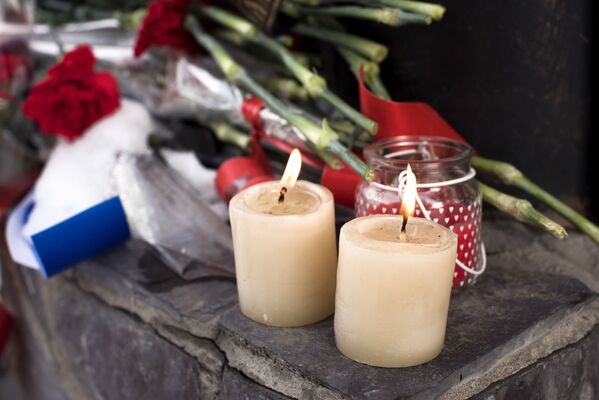 Цветы и свечи у посольства России в Бишкеке в память о погибших при крушении самолета Ту-154