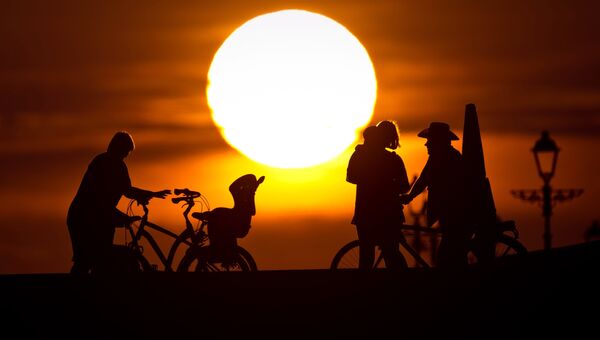 Велосипедисты на закате на набережной недалеко. Архивное фото