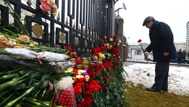 Мужчина возлагает цветы в память о погибших в авиакатастрофе Ту-154 в Сочи у посольства России в Минске