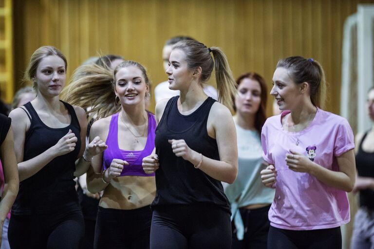 Участницы группы поддержки Черри хоккейного клуба Авангард разминаются на тренировке