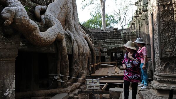 Туристы в храме Та Прум, являющимся частью архитектурного комплекса Ангкор на северо-западе Камбоджи