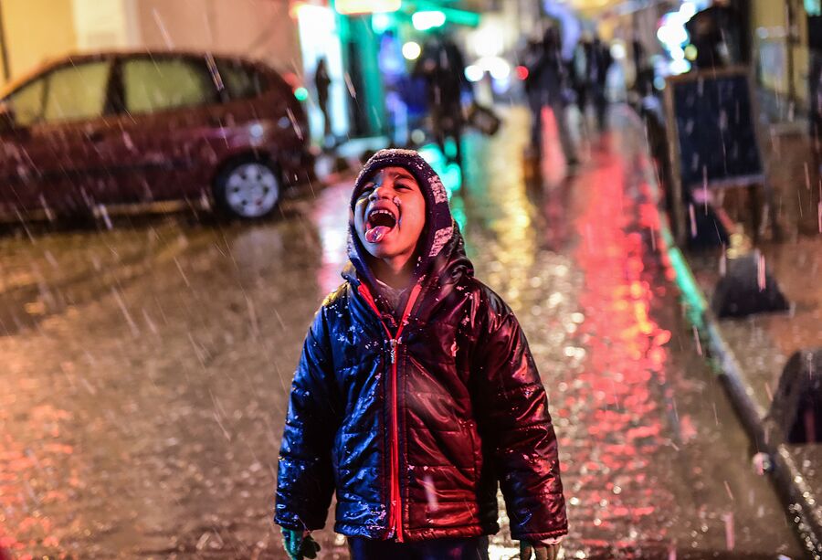 Мальчик радуется снегу в Стамбуле, Турция 