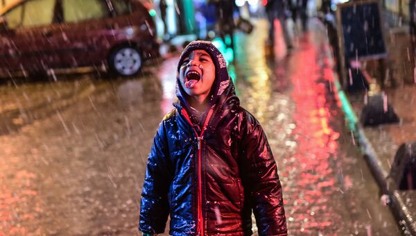 Мальчик радуется снегу в Стамбуле, Турция