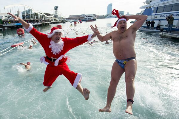 Участники традиционного рождественского заплыва Copa Nadal в костюмах Санта-Клаусов в порту Барселоны