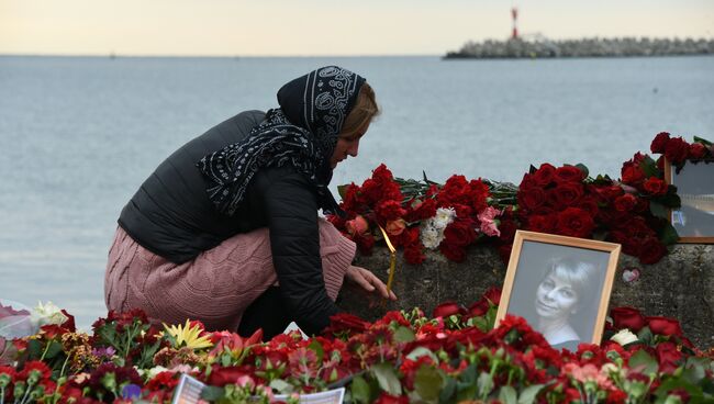 Женщина зажигает свечу в память о жертвах крушения самолета ТУ-154 в Сочи. Архивное фото
