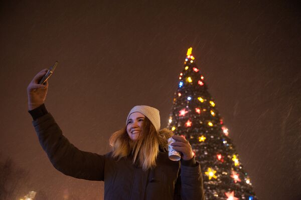 Девушка фотографируется на центральной площади в Томске во время встречи Нового 2017 года