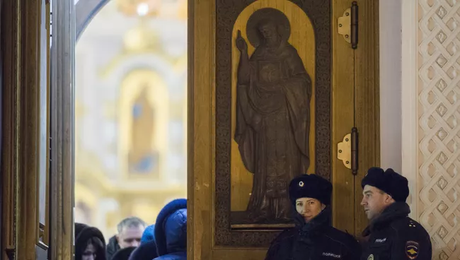 Сотрудники полиции у входа в храм во время Рождественского богослужения