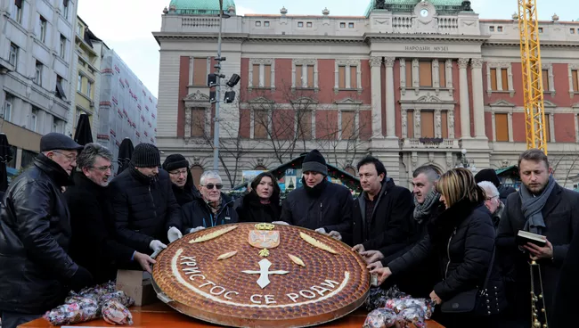 Жители Белграда с рождественским пирогом Божична чесница