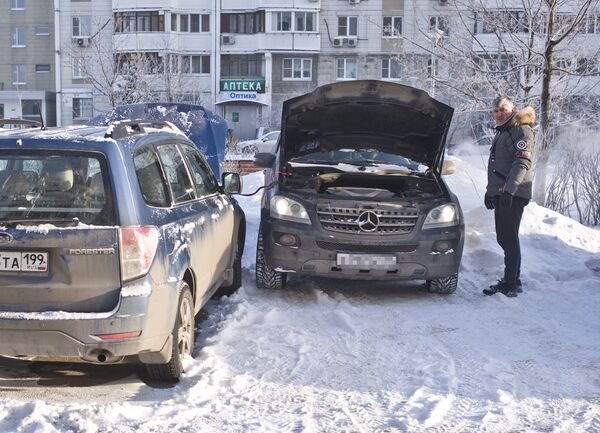 Автомобилист заряжает аккумулятор своего автомобиля в Москве