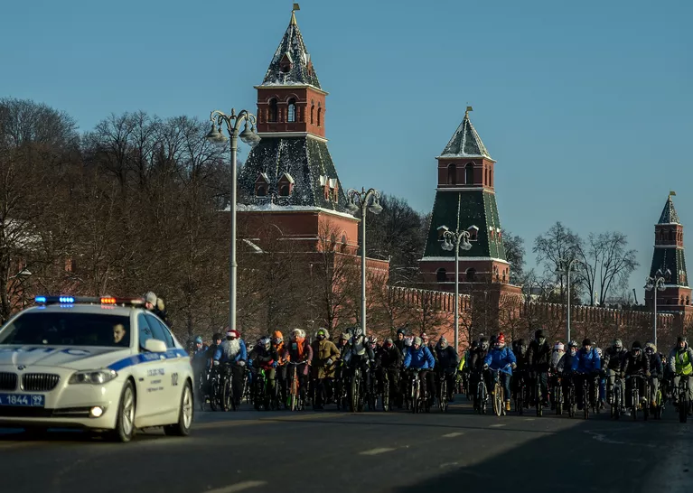 Участники Второго зимнего Московского Велопарада в сопровождении машины сотрудников ДПС на Кремелвской набережой