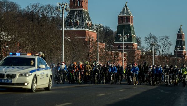 Участники Второго зимнего Московского Велопарада в сопровождении машины сотрудников ДПС на Кремелвской набережой