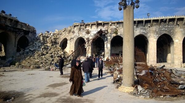 Горожане во дворе Мечети Омейядов в Алеппо, разрушенной в результате боевых действий