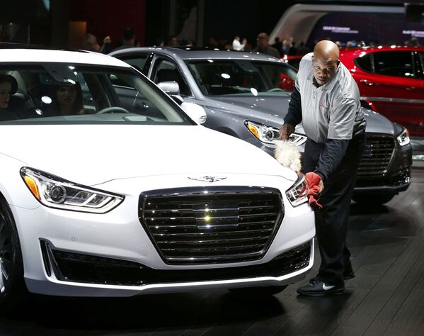 Сотрудник протирает автомобиль Hyundai Genesis на автосалоне в Детройте