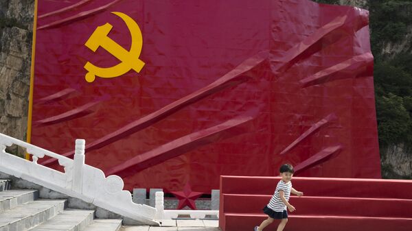 Ребенок на фоне флага Коммунистической партии Китая