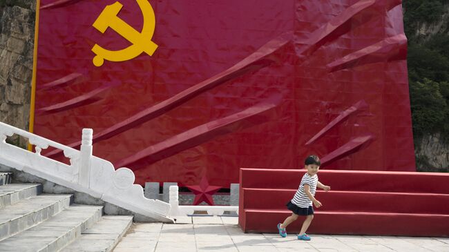 Ребенок на фоне флага Коммунистической партии Китая. Архивное фото