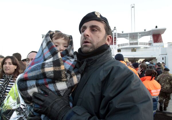 Полицейский с ребенком, спасенным с круизного судна Коста Конкордия