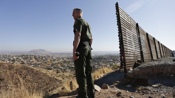 Сотрудник правоохранительных органов США у стены на границе США и Мексики в Сан-Диего