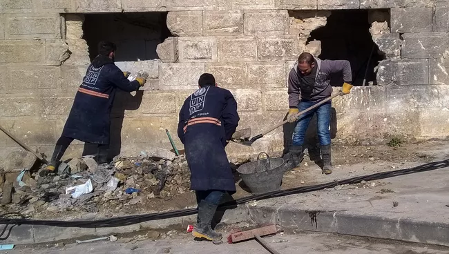 Горожане во время уборке на улице в районе Аль Назирия в сирийском Аллепо. Архивное фото