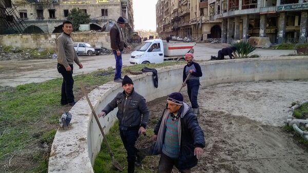 Горожане во время уборке на улице в районе Аль Назирия в сирийском Аллепо