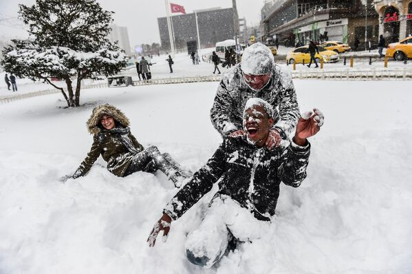 Люди на площади Таксим во время снегопада в Стамбуле