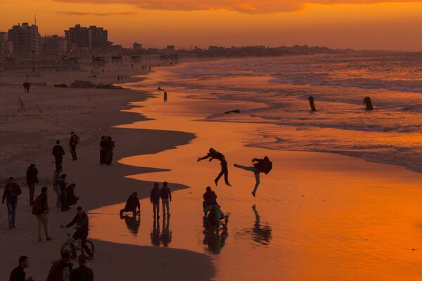 Жители Палестины во время заката на пляже в городе Газа