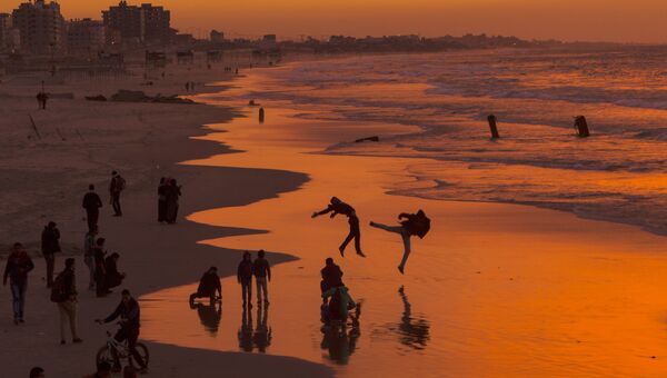 Жители Палестины во время заката на пляже в городе Газа. Архивное фото