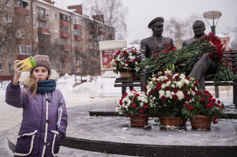 Девочка фотографируется на фоне памятника конструктору пилотируемых космических кораблей Сергею Королеву и первому космонавту Земли Юрию Гагарину в Королеве