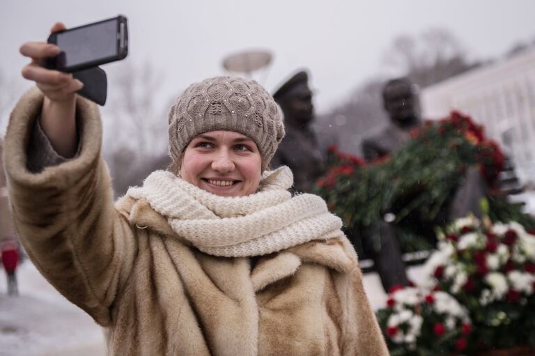 Женщина фотографируется на фоне памятника конструктору пилотируемых космических кораблей Сергею Королеву и первому космонавту Земли Юрию Гагарину в Королеве